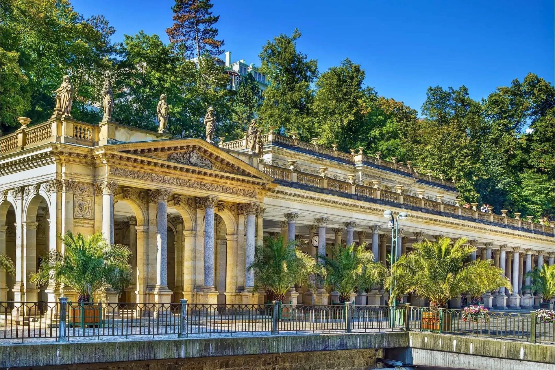 The elegant colonnades and spa architecture of Karlovy Vary rising above the river.